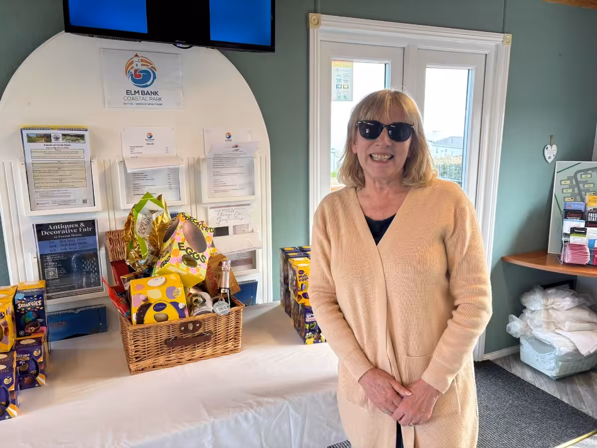 An owner at Elm Bank Coastal Park in Berwick, Northumberland standing next to an Easter Egg hamper which was raffled to support our local charity.
