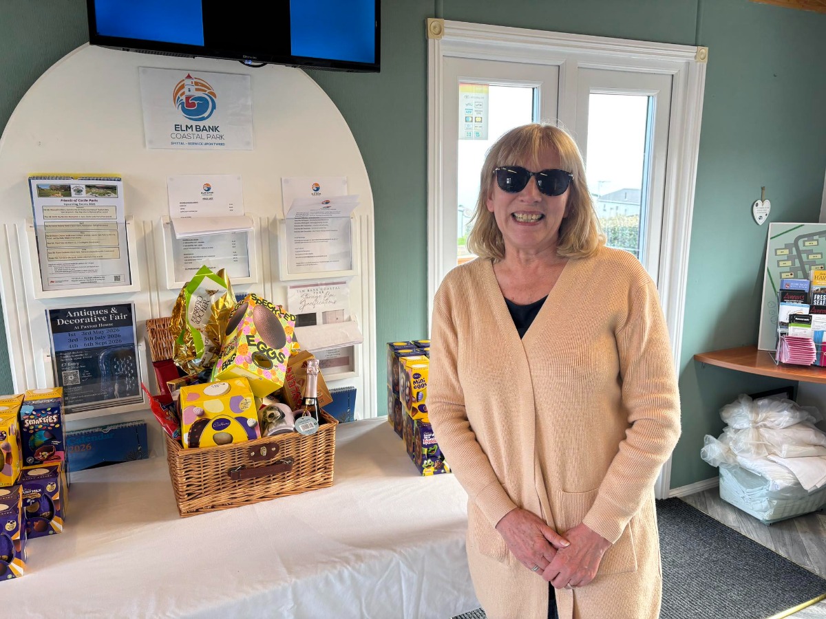 An owner at Elm Bank Coastal Park in Berwick, Northumberland standing next to an Easter Egg hamper which was raffled to support our local charity.