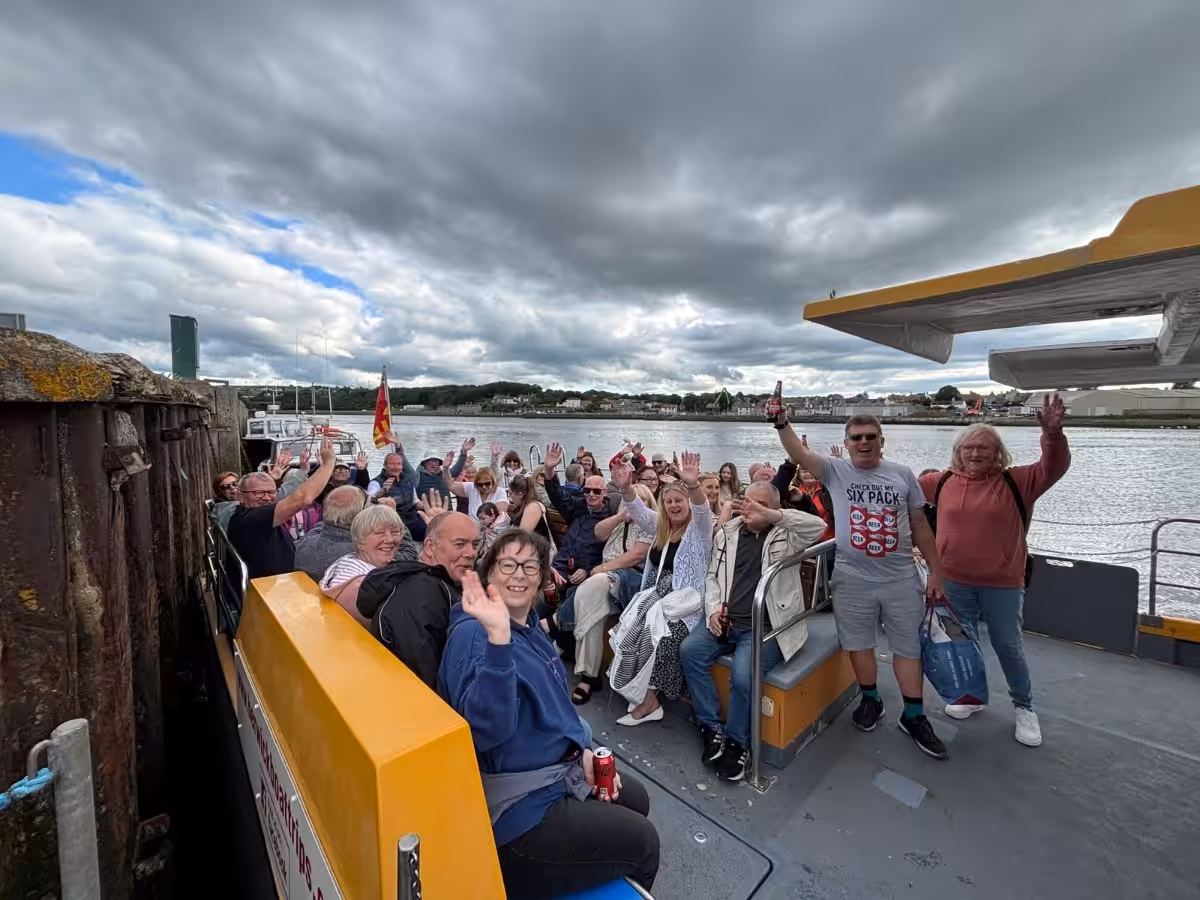 Owners from Elm Bank Coastal Park in Berwick, Northumberland sitting on a boat waving at the start of the hugely popular annual summer evening boat trip.